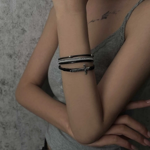 Bohemian multilayer leather bracelet with cross charm and Blessed engraving on a model's wrist