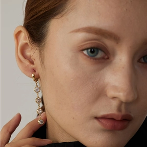 Elegant gold stainless steel tassel earrings featuring four clear geometric zircons