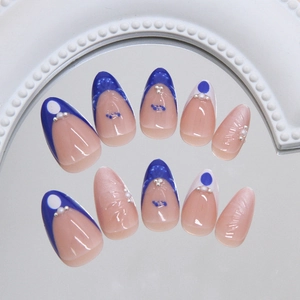 Faux ongles amande bleu français avec fleurs en perles 3D et finition oeil de chat