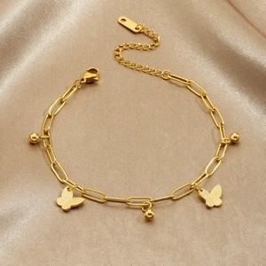 Elegant gold butterfly bracelet with bead accents on luxury silk background