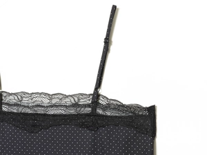 Détail de haut noir à pois avec bordure en dentelle fine et fines bretelles