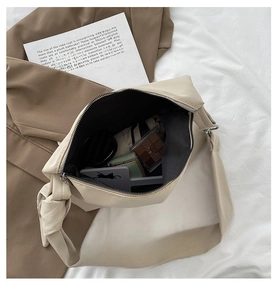 Interior view of beige crossbody bag showing ample capacity for cosmetics and accessories
