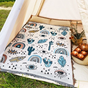 Close-up of Bohemian picnic blanket with rainbow patterns inside a camping tent