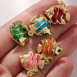 Macro detail of five colorful enamel fish pendants in gold plating for DIY jewelry making