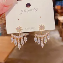 Detailed view of gold star and crescent moon drop earrings with S925 silver needles