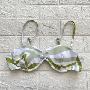 Detail of green zebra print bikini top with underwire and thin straps on white background