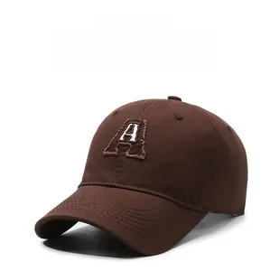 Detailed close-up of letter A embroidery on a coffee brown cotton baseball cap
