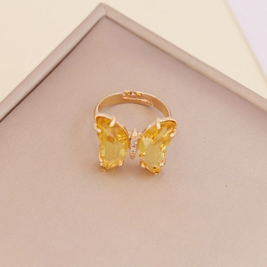 Macro detail of adjustable gold ring featuring a yellow zircon butterfly design