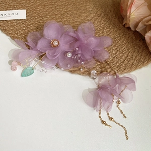 Détail de la pince à fleurs en tulle violet avec glands en perles dorées et perles de feuilles