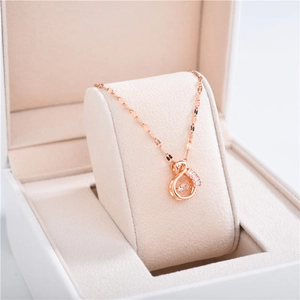 Detailed close-up of rose gold swan pendant with sparkling zircons in a jewelry box