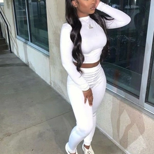 Tenue blanche deux pièces ajustée avec haut court à manches longues et pantalon moulant