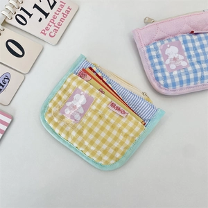 Detailed view of quilted cotton coin purses with heart stitching and cute bear patches
