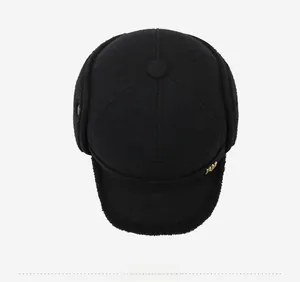 Top down view of black wool winter baseball cap with ear flaps and metal logo detail