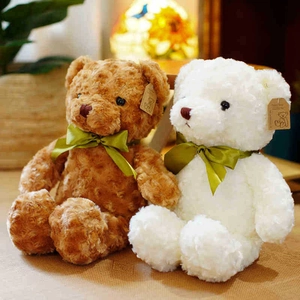 Set of two soft plush teddy bear toys in brown and white colors with elegant green bows