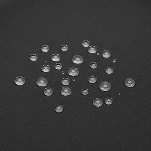 Macro shot of water-resistant fabric showing hydrophobic droplets on high-density material