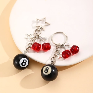 Detail of 8-ball and cherry resin charms on stylish silver metal keychains