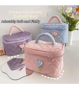 Detailed close-up of quilted corduroy cosmetic bags with tulip patches and sturdy handles