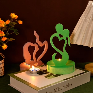 Detail view of abstract couple silhouette candle holders on book for home decor