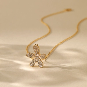 Detailed close-up of 18K gold-plated fan-shaped flower pendant with inlaid cubic zirconia