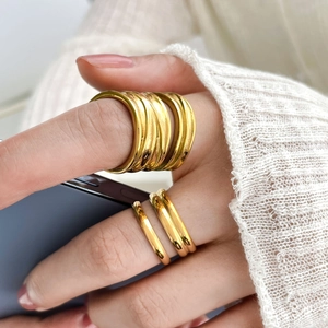 Detailed view of layered 18K gold plated titanium steel rings on model's hand