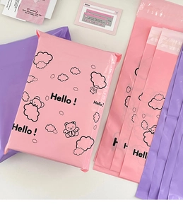 Detail of pink and purple mailing bags featuring cute bear and cloud patterns with Hello text