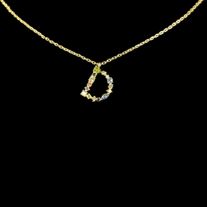 Macro shot of 18k gold letter D pendant with vibrant colorful zircon gemstones
