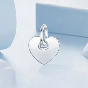 Polished S925 sterling silver heart-shaped pendant with bail on a blue background