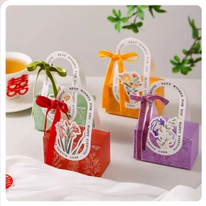 Detail of colorful European-style wedding candy boxes with silk ribbons and floral patterns