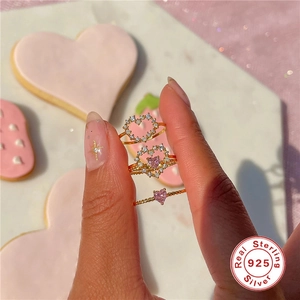 Detailed view of three 925 sterling silver heart rings with pink and white zircons