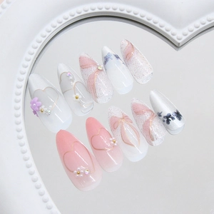 Pink cat eye almond press-on nails with bow, 3D flower and heart details on mirror