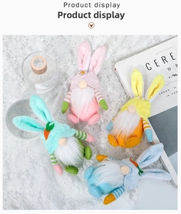 Vista cenital de cuatro coloridos gnomos conejitos de Pascua sobre un mantel de encaje blanco