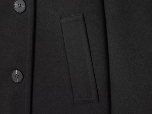 Detail of black wool-blend coat featuring classic buttons and side pocket texture