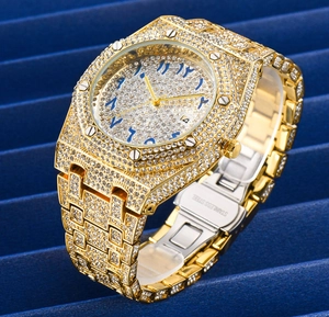 Detail of luxury gold iced-out watch with blue Arabic numerals on a tiered base