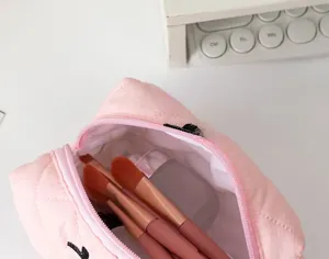 Beauty case trapuntato rosa capiente con pennelli da trucco e flaconi di lozione