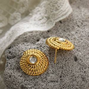 Macro detail of vintage 18K gold plated stud earrings with crystal on lava stone