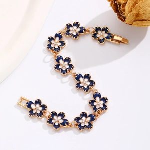 Detail of blue enamel flower bracelet with gold base and white crystal center