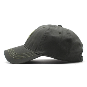 Detail of dark grey cotton baseball cap showing yellow-green contrast stitching on brim
