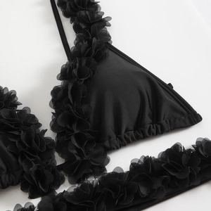 Detailed close-up of a black bikini top with 3D mesh floral lace and mesh petal trim