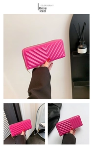 Vue détaillée du portefeuille long fuchsia matelassé en V avec fermeture éclair dorée