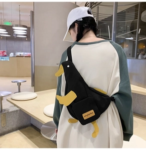 Detail of cute black duck-shaped canvas crossbody bag shown on a person back view