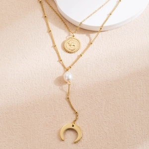 Détail du collier multicouche doré avec pendentifs pièce de monnaie et croissant de lune