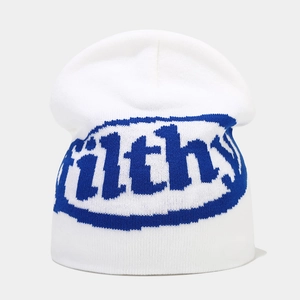 Close-up of white knit beanie featuring blue filthy jacquard letters and thick texture