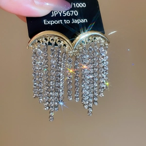 Détails macro de boucles d'oreilles lune avec pampilles et cristaux étincelants