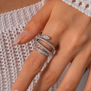 Close-up of layered crisscross ring with pavé-set zircons on white knit background