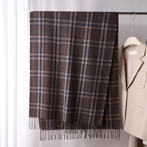 Close-up of brown and dark blue plaid scarf featuring soft texture and tassel details