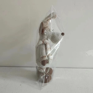 Standing grey plush mouse doll wearing striped scarf in clear plastic packaging