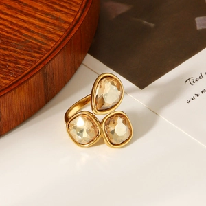 Detailed macro view of 18k gold ring featuring amber teardrop and square gemstones