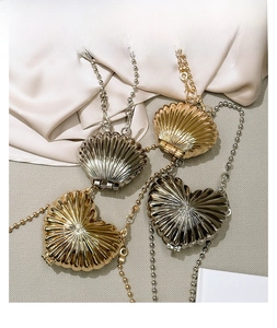 Detail view of mini zinc alloy shell and heart bags with textured pleats and bead chains