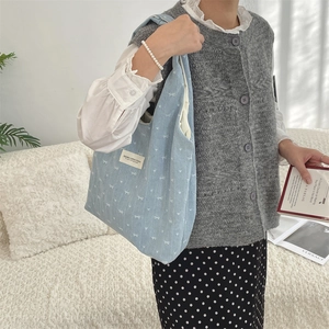 Détail du sac cabas en toile bleu clair avec imprimé nœud et étiquette Siyarka