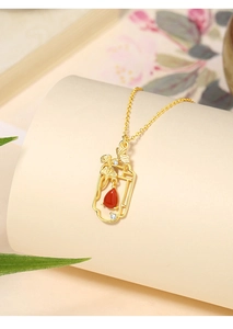 Detail of 925 silver necklace with red agate teardrop and golden ginkgo leaf pendant